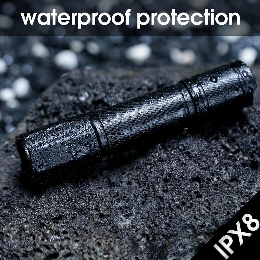 Black waterproof flashlight with IPX8 rating on wet rock, water-resistant protection