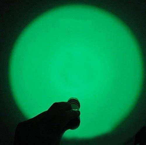 Hand holding flashlight projecting bright green beam onto wall