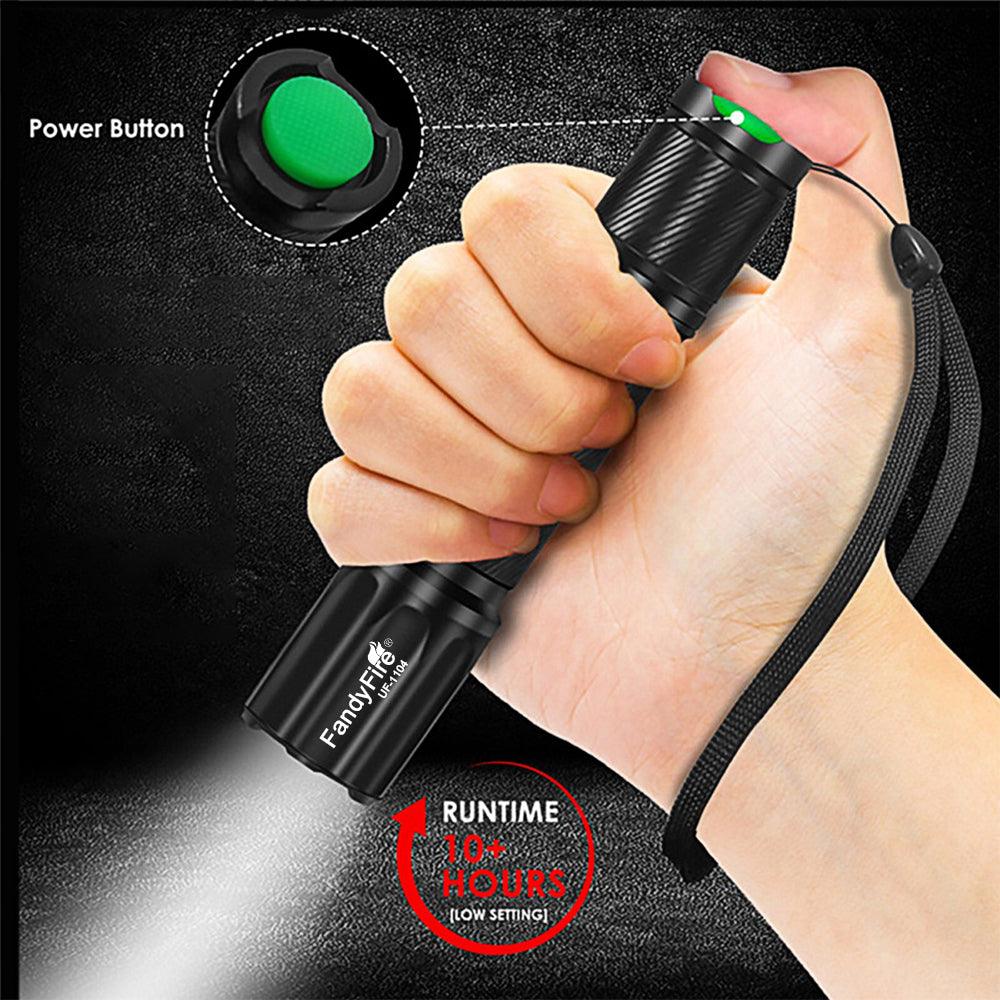 Hand holding black FandyFire LED flashlight with green power button and wrist strap